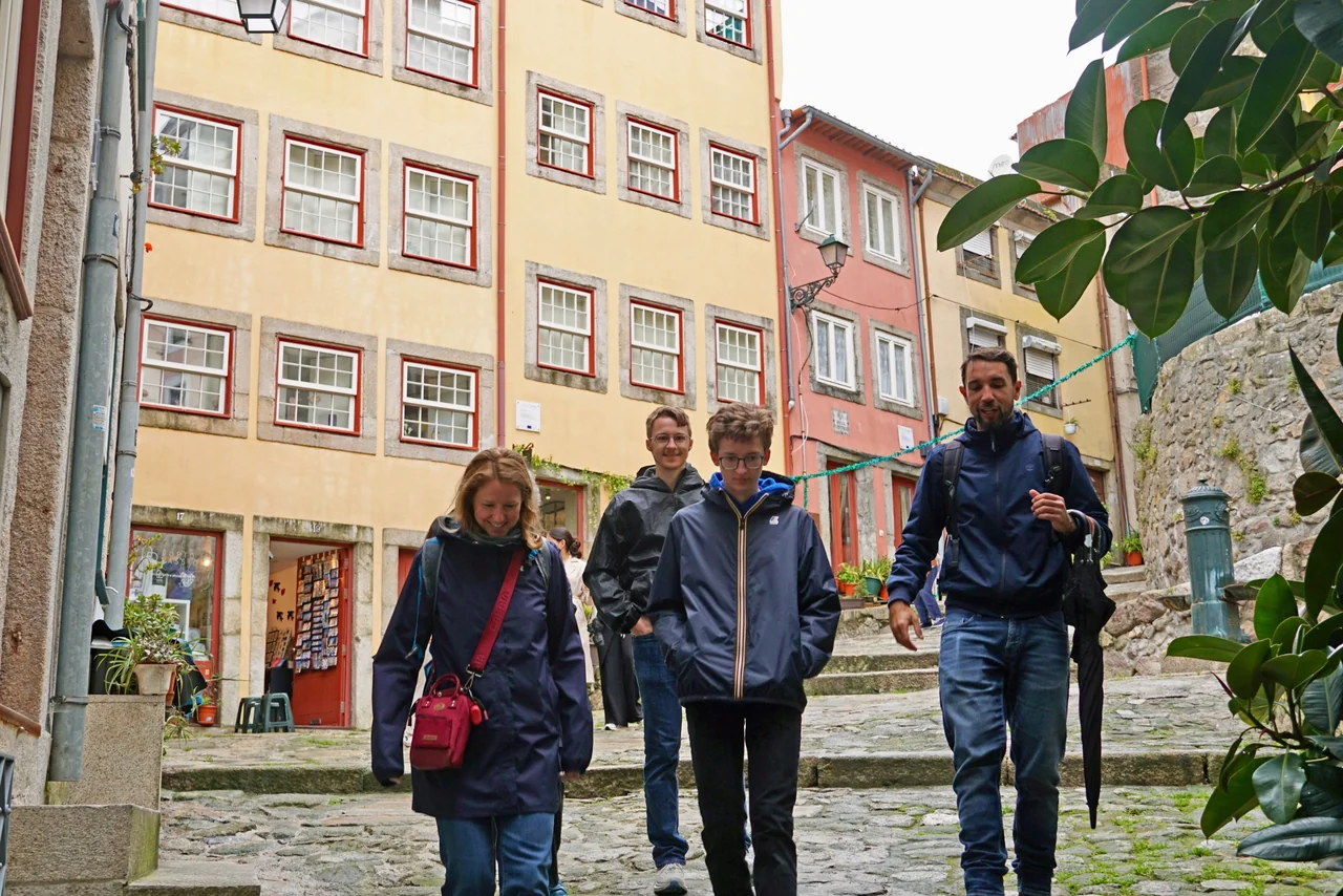 Thiago Costa walking with a family through a sloping historic street in Porto.
